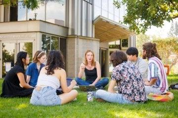 Students sit in a circle outside Benson Auditorium